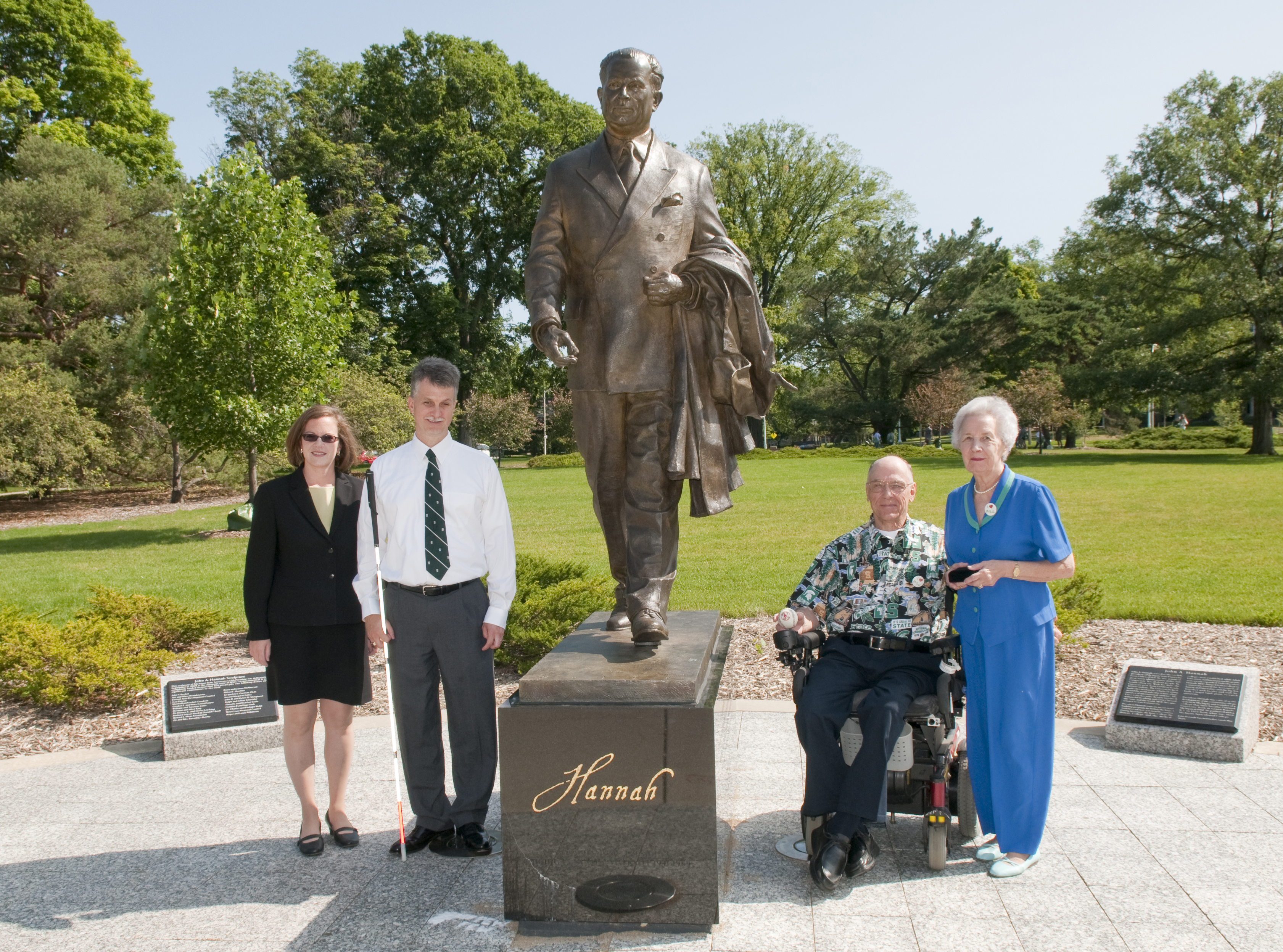 Harold and Phyllis Wochholz standing with RCPD Director Hudson and MSU staff in front of John Hannah statue on campus