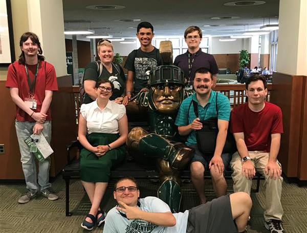 Photo of BOND early move-in group posting with a statue of Sparty