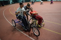 Members of the MSU Adaptive Sports Club test out the new adaptive cycle at their regular club gathering.