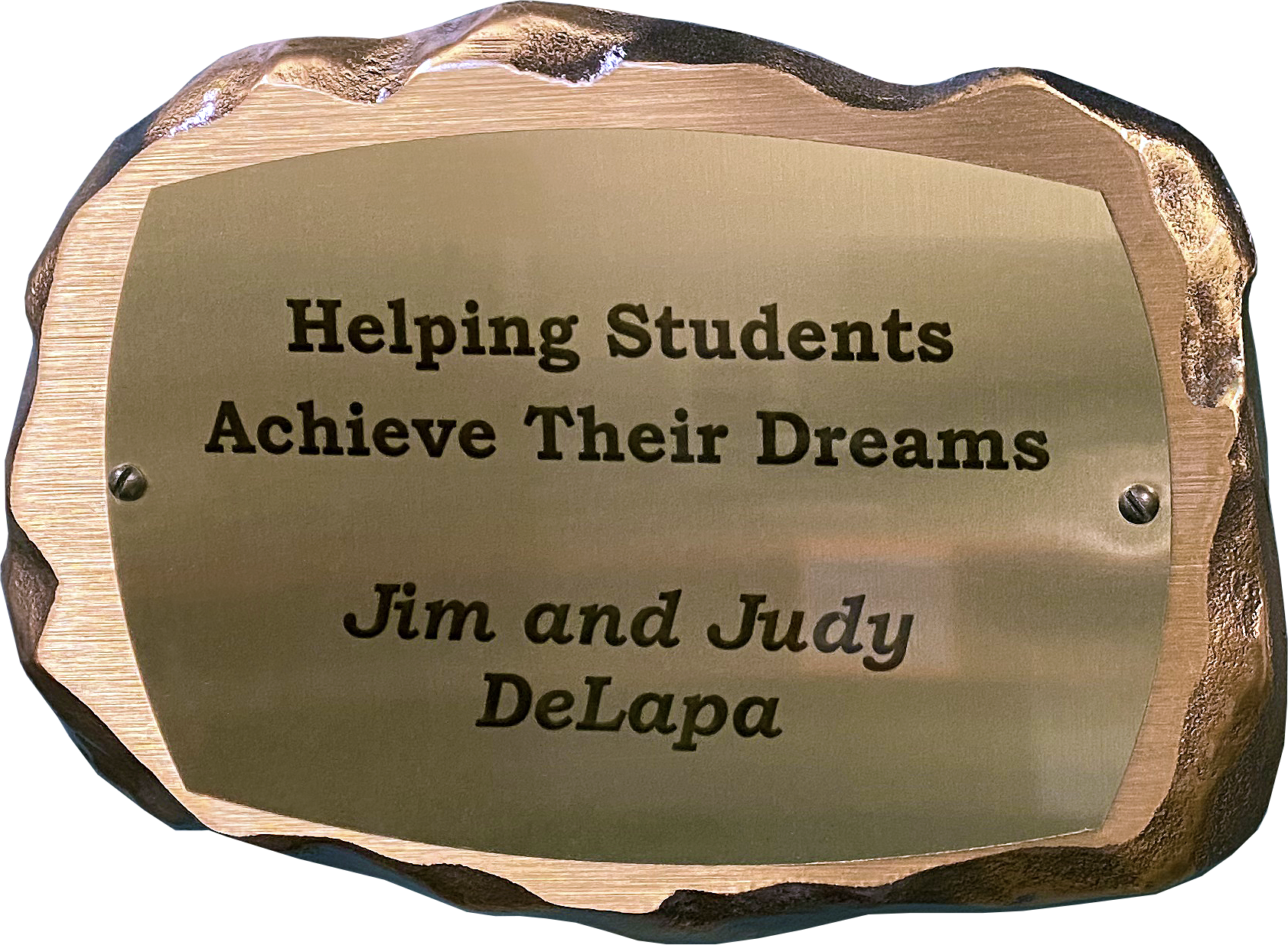 Inscribed bronze plaque in the shape of a rock with text on it reading: Helping Students Achieve Their Dreams. Jim and Judy DeLapa