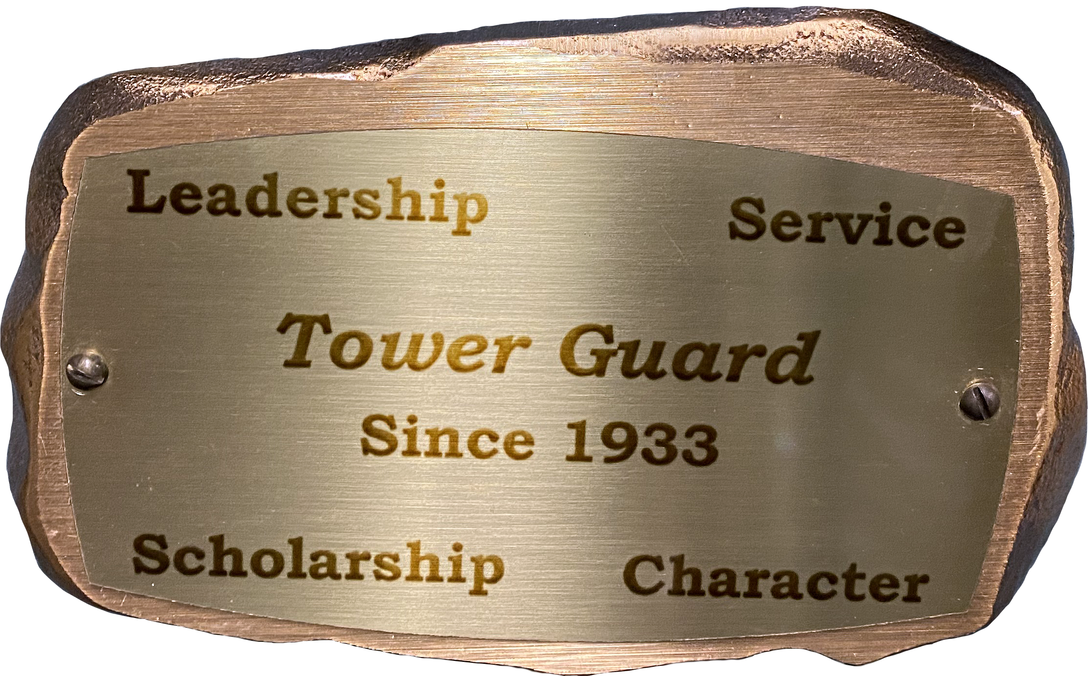 Inscribed bronze plaque in the shape of a rock with text on it reading: "Leadership, Service, Tower Guard, Since 1933, Scholarship, Character"