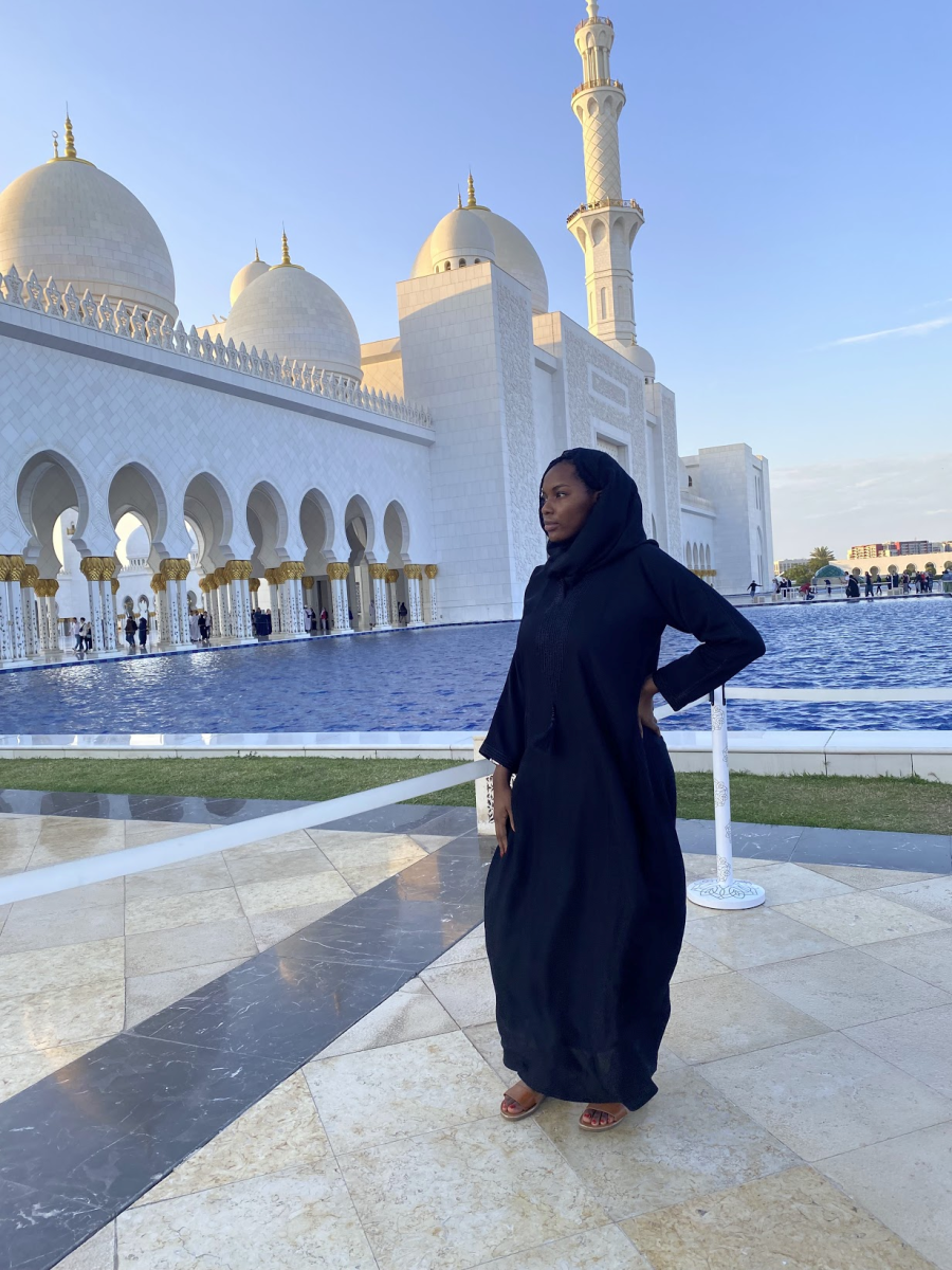A picture of Danielle dressed in traditional Abaya Arabic clothing with landscape of Dubai in the background