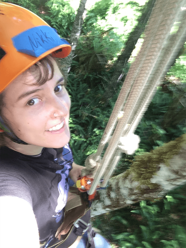 Photo of student smiling while high up in tree