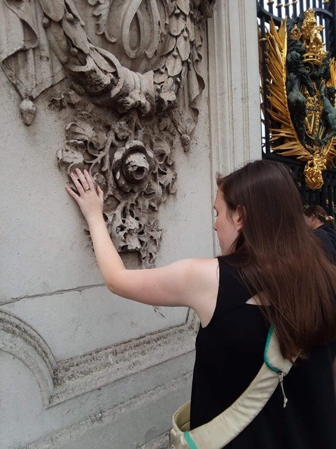 Photo of Ellie touching ornate building decoration