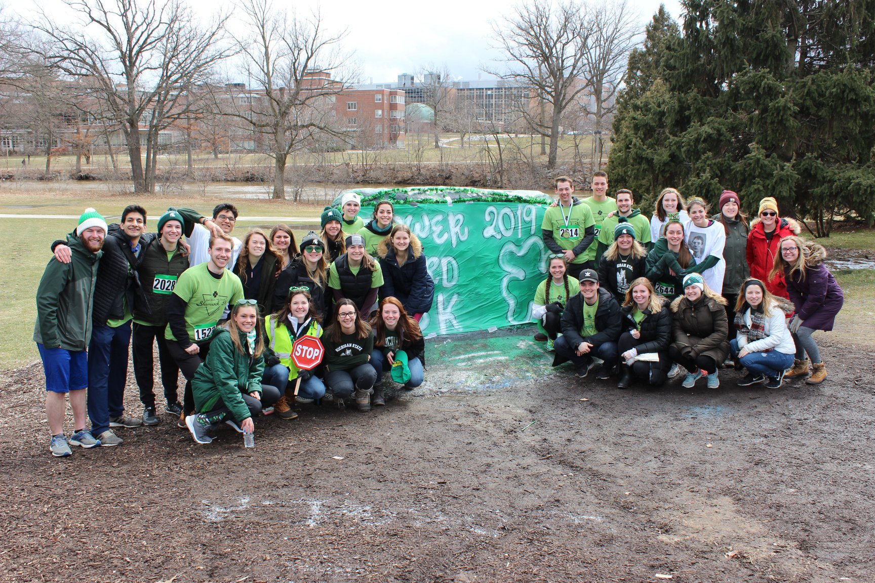 Group of people around the Rock that is painted in green