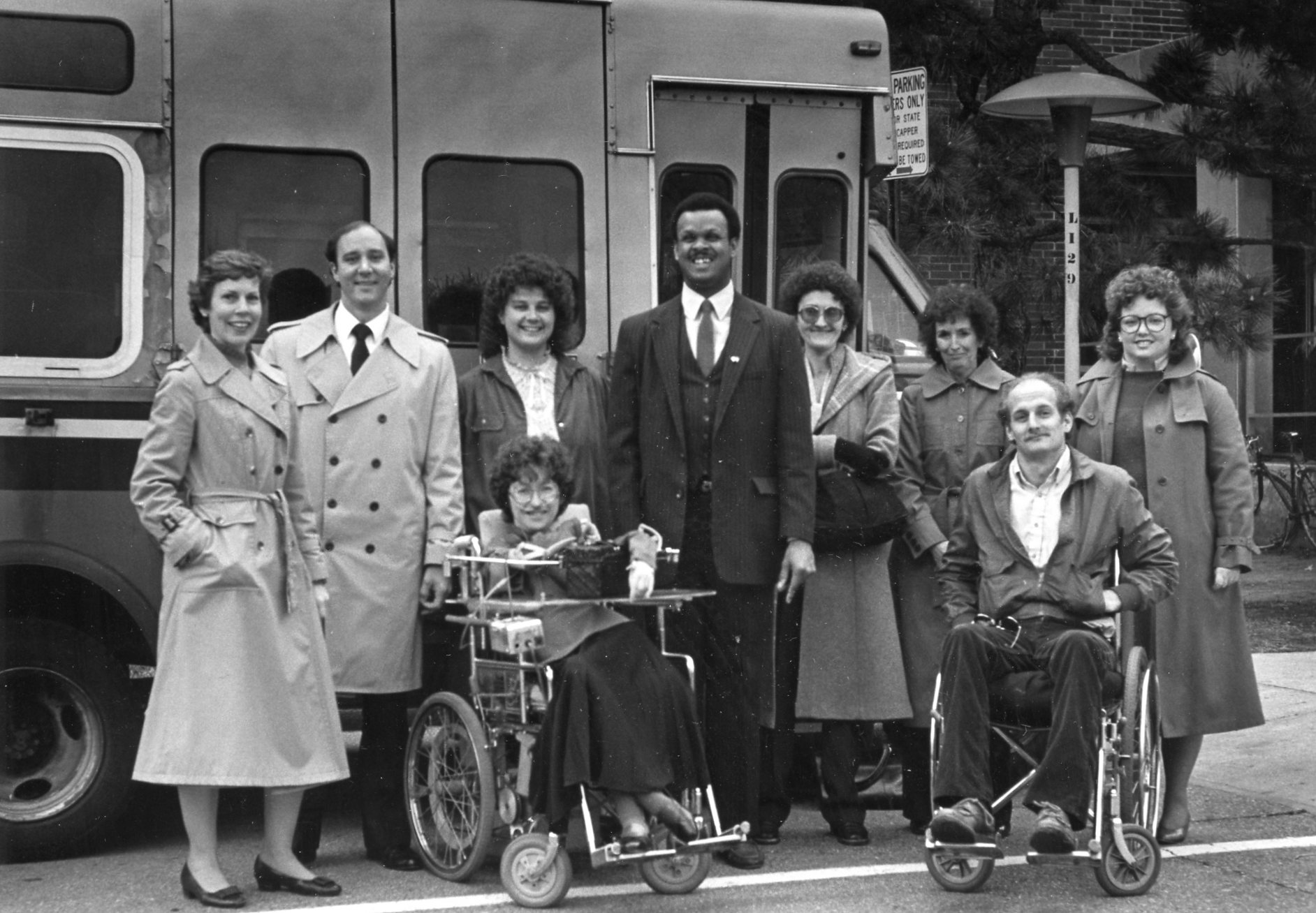 Black and white photo of HSP staff in front of accessible van