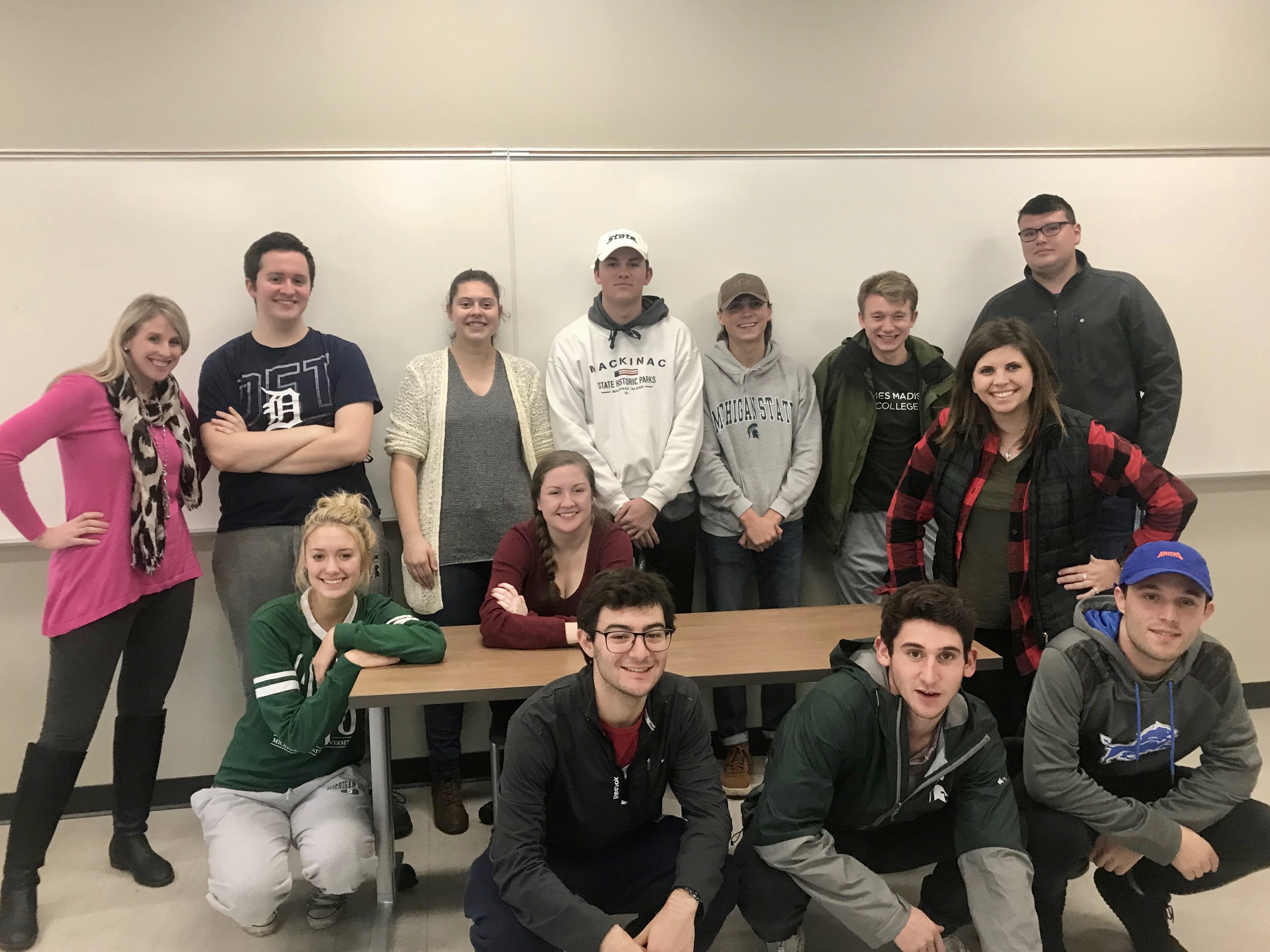 Students and instructors pose for a group photo in front of the classroom. 