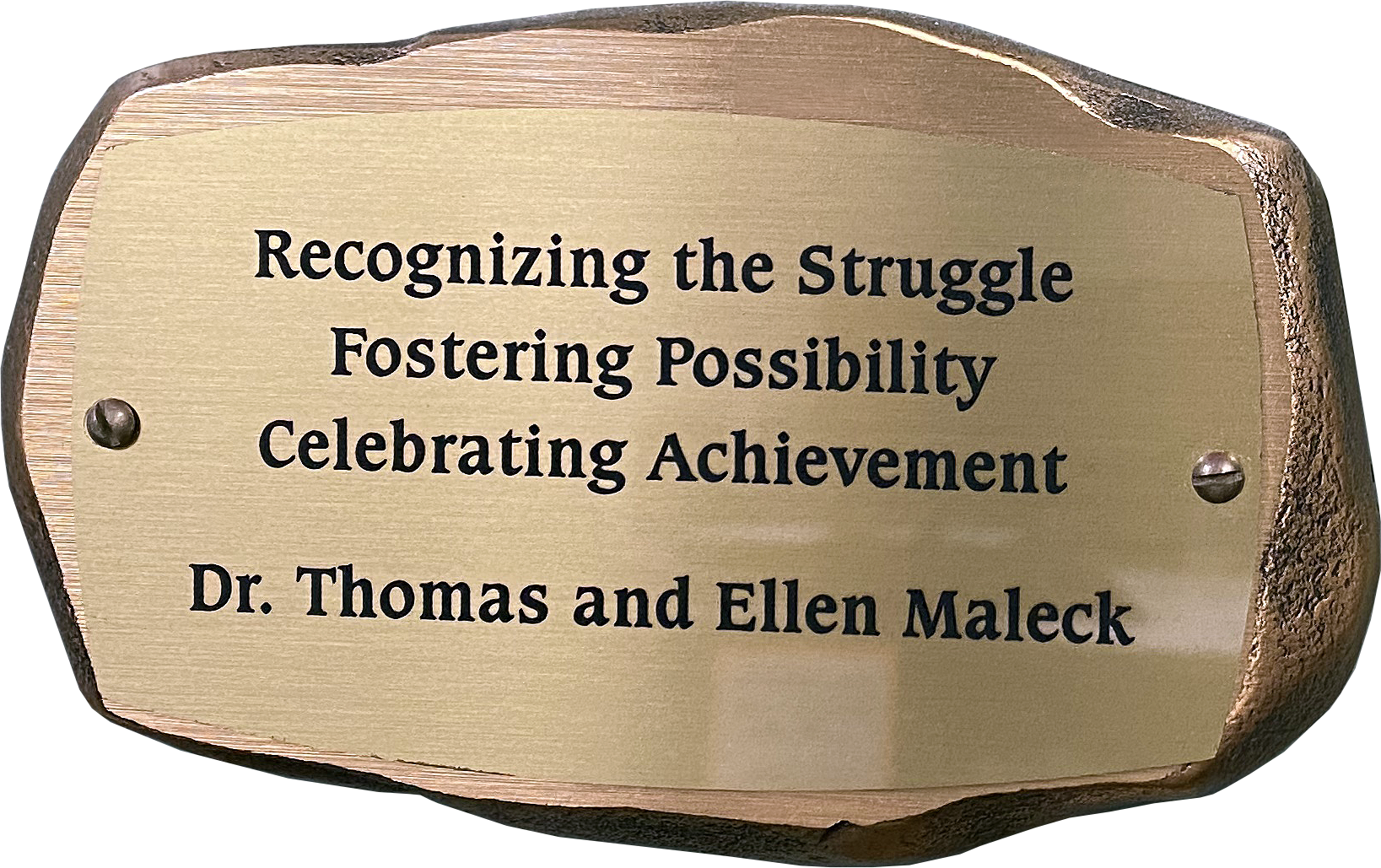 Inscribed bronze plaque in the shape of a rock with text on it reading: Recognizing the Struggle, Fostering Possibility, Celebrating Achievement. Dr. Thomas and Ellen Maleck