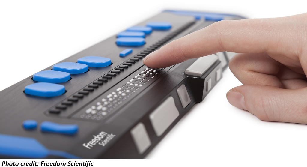 Photo of a Freedom Scientific Focus Blue electronic braille display with a hand reaching in to feel the refreshable braille. Photo credit: Freedom Scientific.