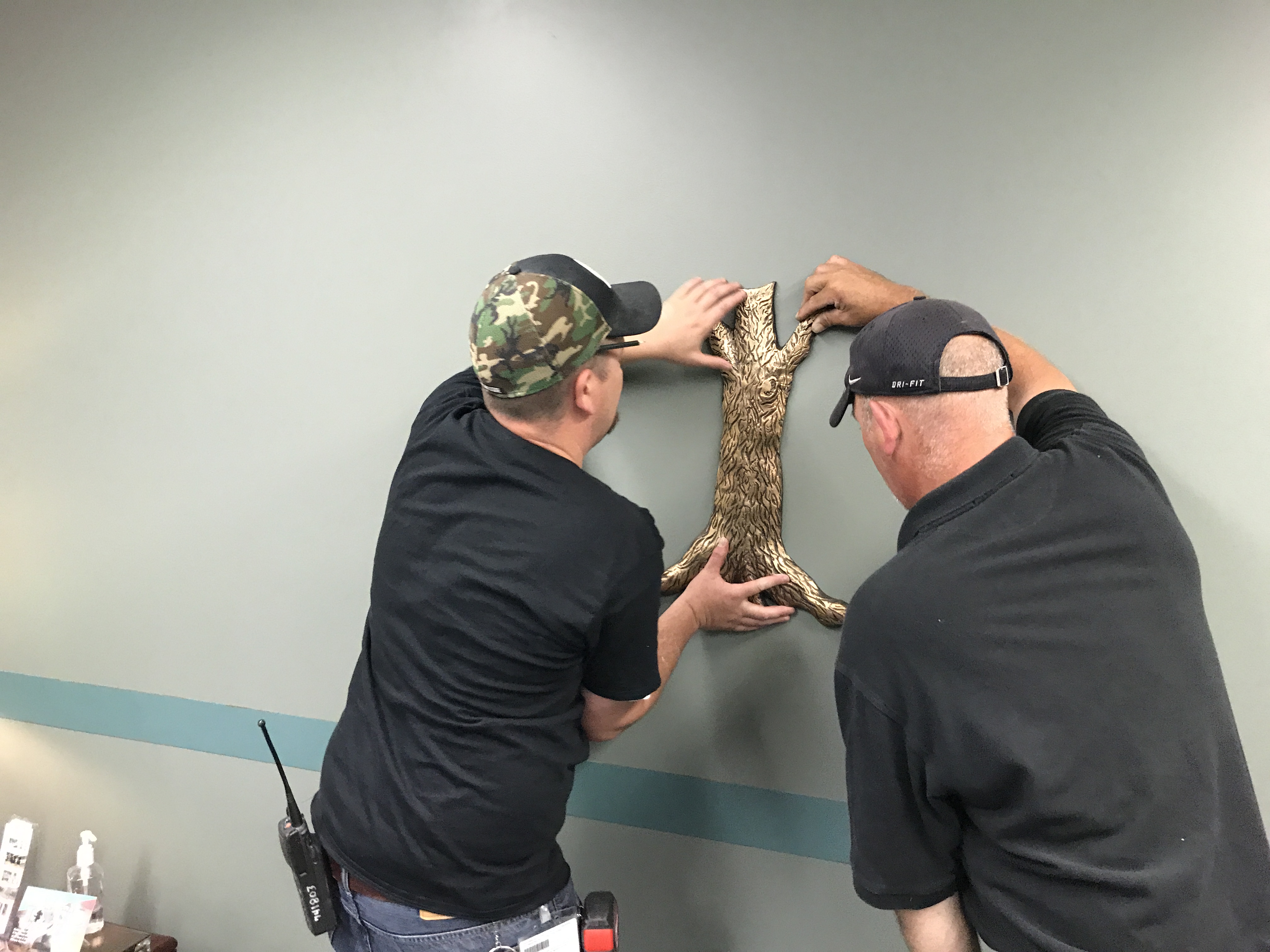 Photo of IPF employees mounting tree base to the wall