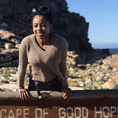 Picture of Sheritha posing with the Cape of Good Hope sign marking the most south-western point of the African continent