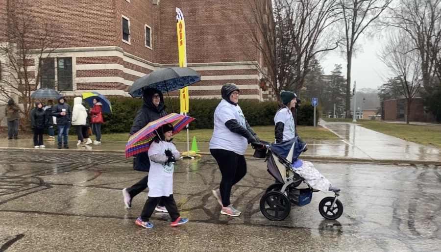 A family of partcipants walking and pushing a stroller in the race