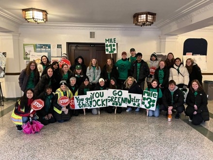 Group Photo of Tower Guard members at race holding encouraging signs for the race particiapants