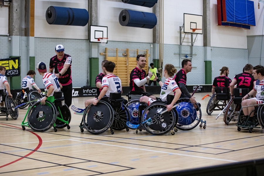 The Wheelchair Floorball Team shown giving high-fives to opponents at end of a game