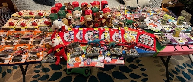 A picture of a table full of toys, including teddy bears, coloring books, and dinosaurs
