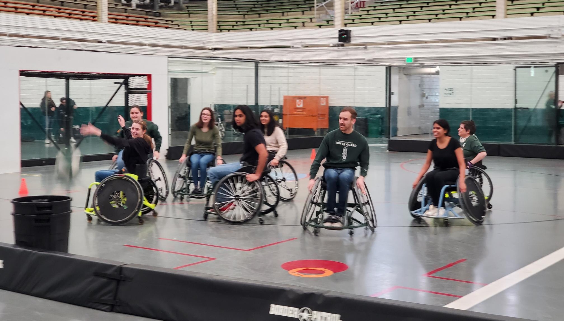 An action shot of some students in wheelchairs playing trashketball