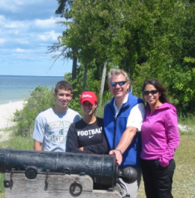 The Powell family standing near a beach, posing with an old cannon