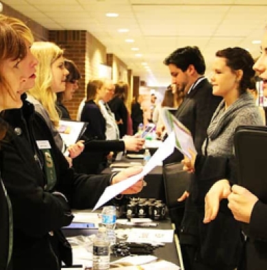 Pictured are MSU students professionally dressed for an internship/job fair, speaking with potential employers.
