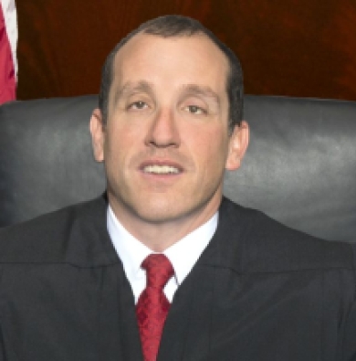 Justice Bernstein, a caucasian man with short brown hair, in a court room. 