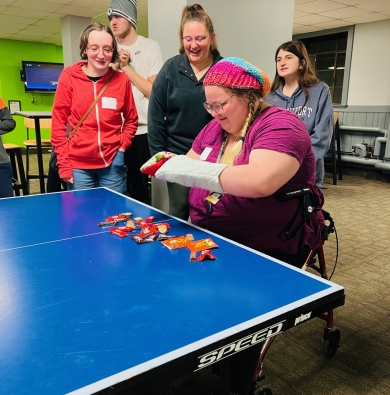 Group of students gathered around a table playing a game.